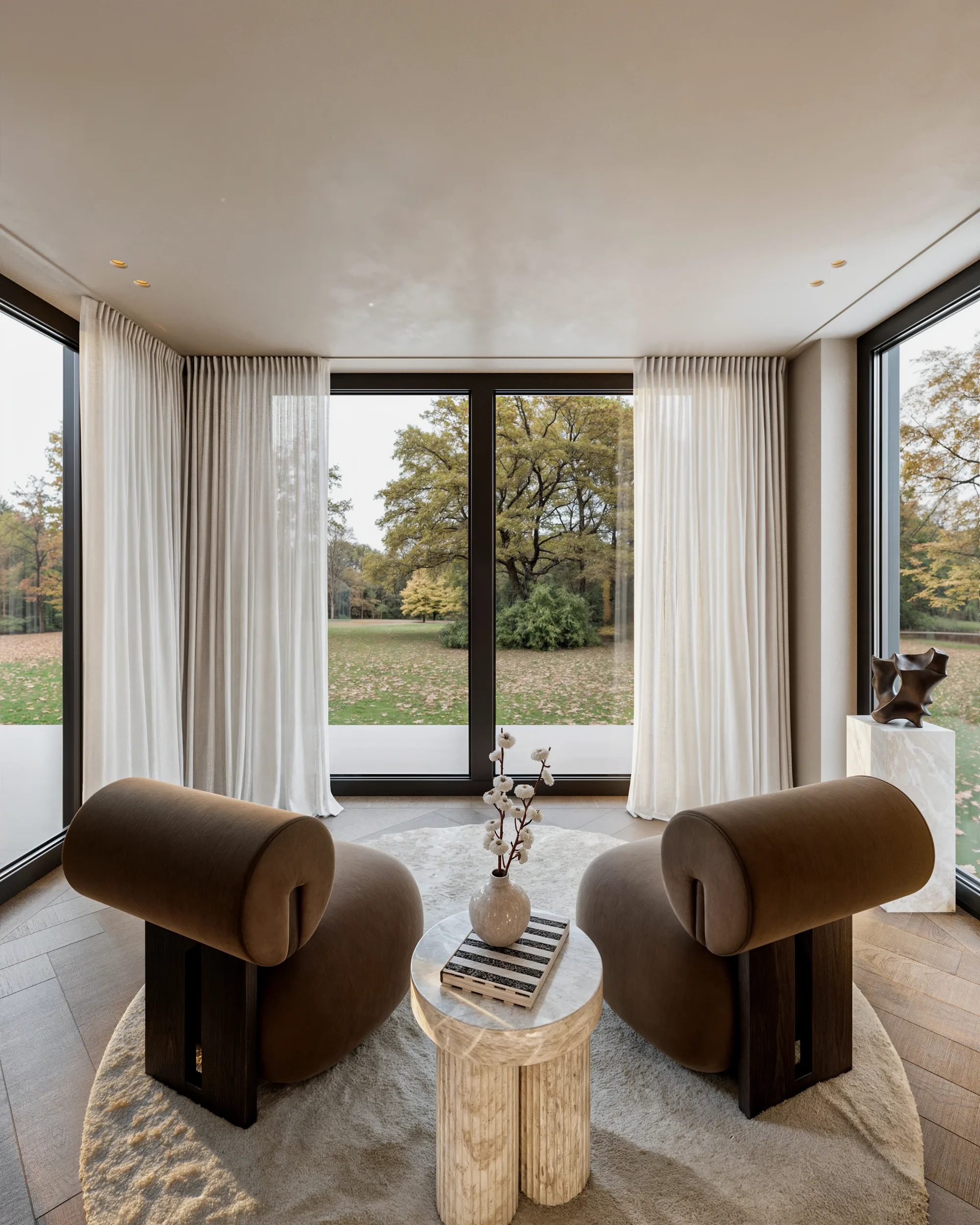 Woonkamer met maatwerkkast, bruine fauteuils en zicht op het park